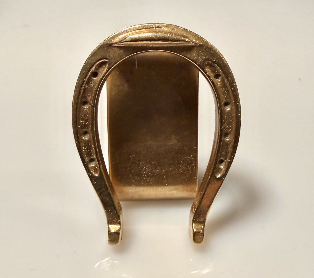 14K Gold Horseshoe Form Money Clip: Approx. dimensions 1 1/2" x 1 1/4". Marked Jost 14K. Approx. gross weight 21.4 grams. STERLING ASSOCIATES STRIVES TO PROVIDE ACCURATE, OBJECTIVE, & FAIR INFORMATION ONALL LOTS. WE WILL BE HAPPY TO ANS