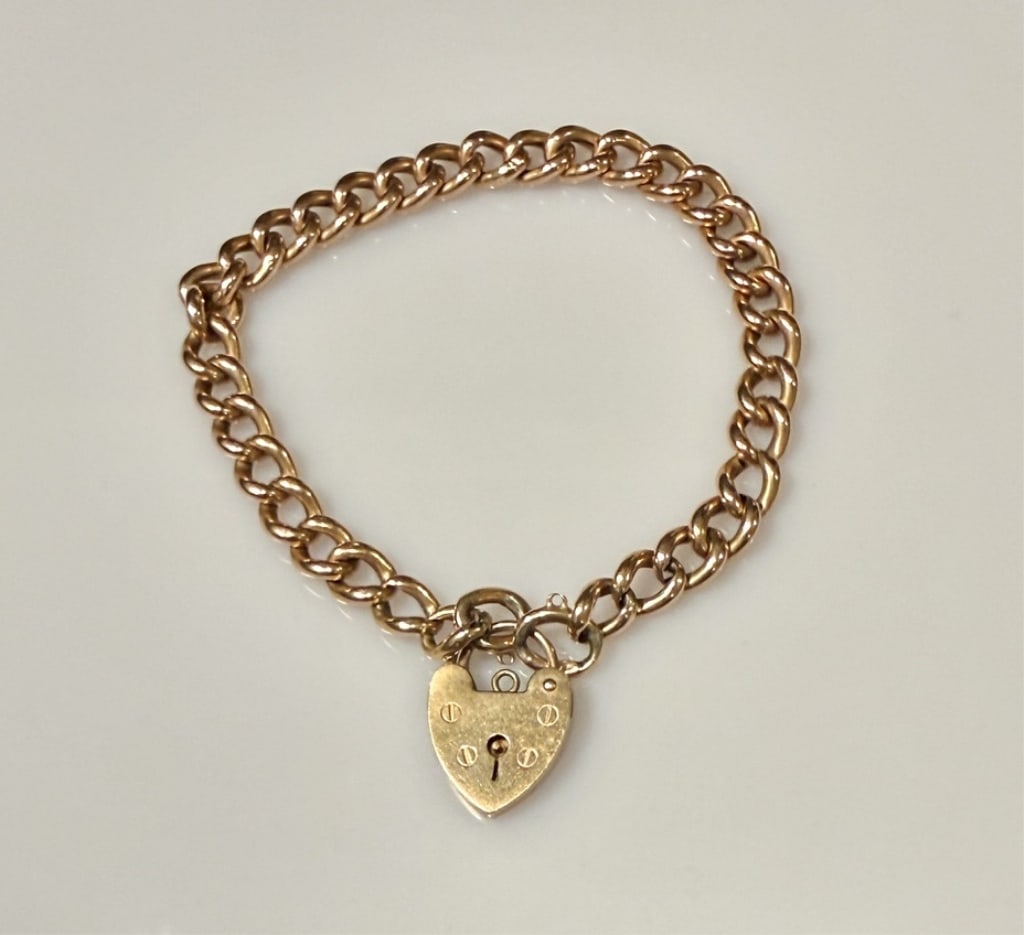 14K And 9K Gold Lock Bracelet: 14K Chain. 9K Lock. Hallmarked. Approx. dimensions 7" length. Tested and marked 14K and 375. Approx. gross weight 10.0 grams.STERLING ASSOCIATES STRIVES TO PROVIDE ACCURATE, OBJECTIVE, & FAIR INFORMAT