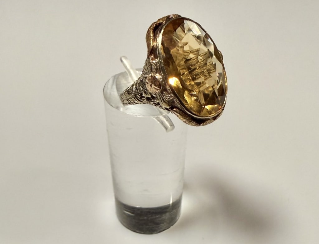 14K Two Tone Gold And Citrine Ring: Ring size 5 1/4. Marked 14K. Approx. gross weight 5.3 grams. STERLING ASSOCIATES STRIVES TO PROVIDE ACCURATE, OBJECTIVE, & FAIR INFORMATION ONALL LOTS. WE WILL BE HAPPY TO ANSWER ANY QUESTIONS AND PRO