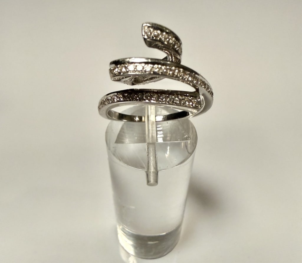 18K White Gold And Diamond Spiral Ring: Ring size 7. Marked 750 for 18K. Approx. gross weight 5.2 grams. STERLING ASSOCIATES STRIVES TO PROVIDE ACCURATE, OBJECTIVE, & FAIR INFORMATION ONALL LOTS. WE WILL BE HAPPY TO ANSWER ANY QUESTIONS AND