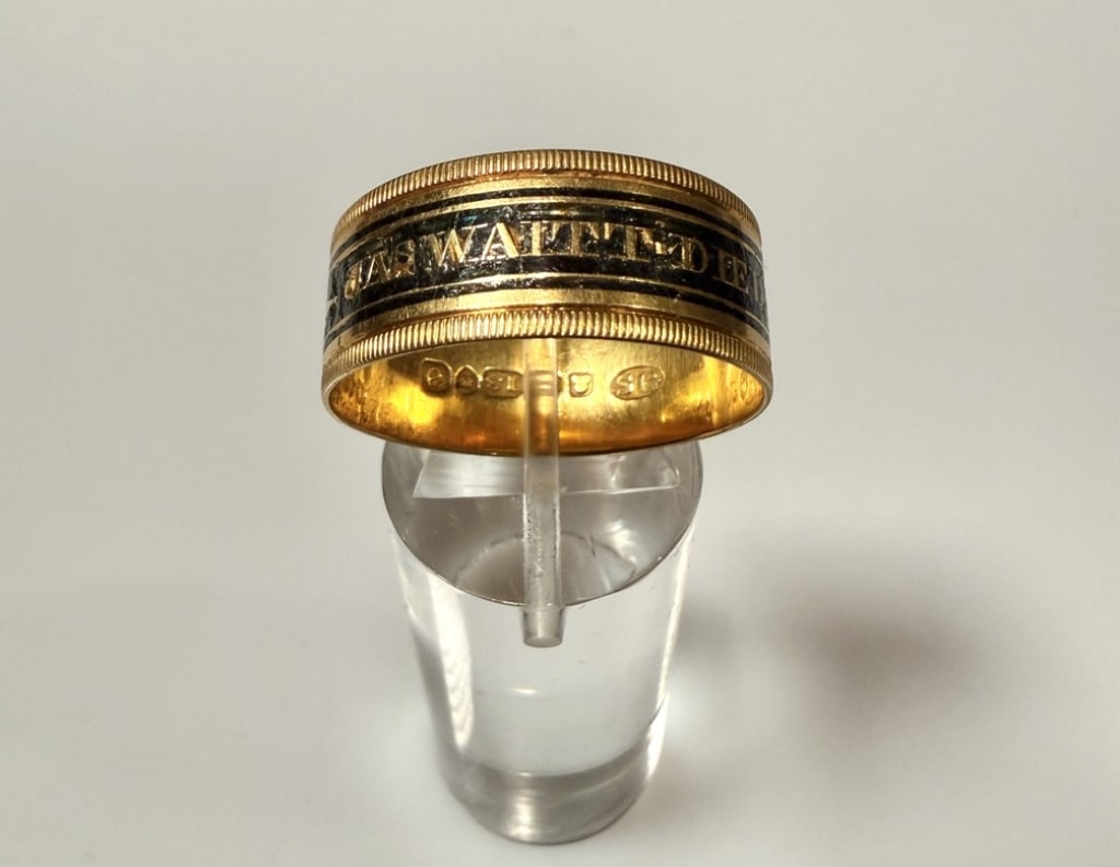 18K Gold And Enamel Mourning Ring From 1816: Ring size 12 1/2. Marked 18K, hallmarks and makers mark. Approx. gross weight 5.5 grams.STERLING ASSOCIATES STRIVES TO PROVIDE ACCURATE, OBJECTIVE, & FAIR INFORMATION ON ALL LOTS. WE WILL BE HAPPY TO