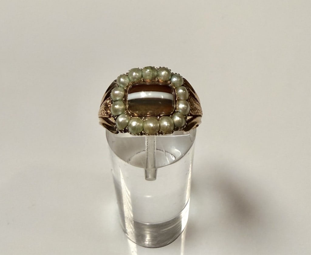 18K Gold, Pearl And Stone Mourning Ring From 1820: Ring size 6 3/4. Tested 18K. Engraved. Approx. gross weight 3.9 grams. STERLING ASSOCIATES STRIVES TO PROVIDE ACCURATE, OBJECTIVE, & FAIR INFORMATION ON ALL LOTS. WE WILL BE HAPPY TO ANSWER ANY QUESTI