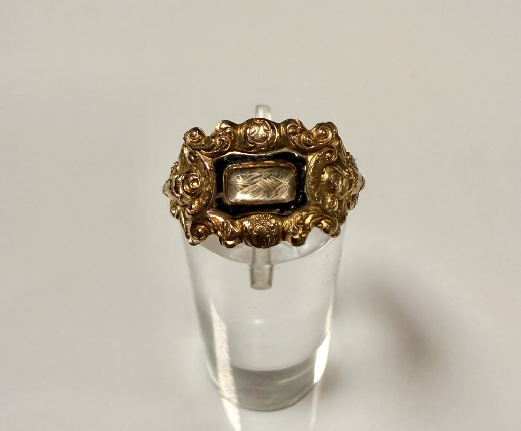 18K Gold And Enamel Embossed Mourning Ring: Ring size 5 3/4. Marked 18K, hallmarks and makers mark. Approx. gross weight 2.6 grams. STERLING ASSOCIATES STRIVES TO PROVIDE ACCURATE, OBJECTIVE, & FAIR INFORMATION ON ALL LOTS. WE WILL BE HAPPY TO