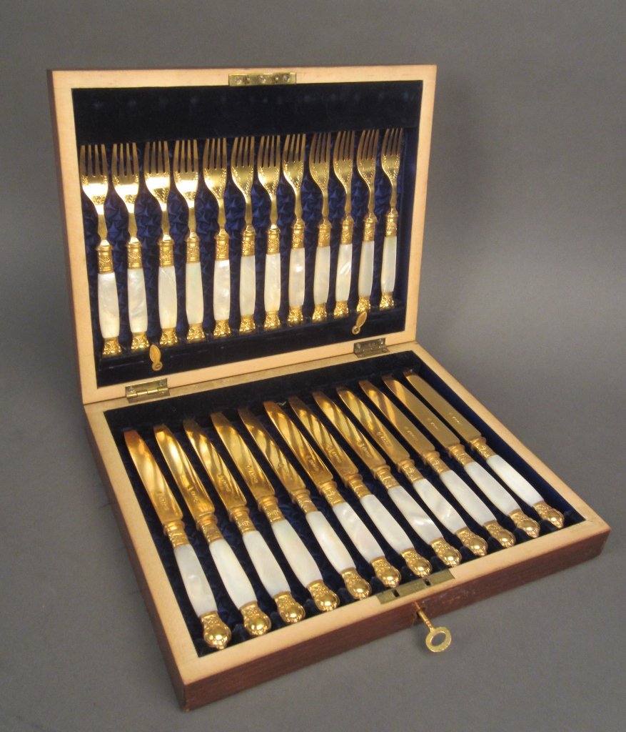 Gilt Knives & Forks in Fitted Wood Case, Set of 12: Set of 12 English gilt forks and knives with mother of pearl handles in fitted wood box. Hallmarks on knives. Inlaid inscription on box: Presented to John A. Wilson, ESQR on the occasion of his marria