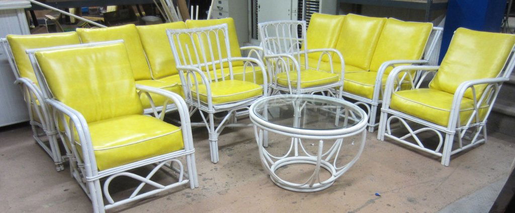 Collection of Rattan Furniture: Collection of white rattan furniture with yellow cushions. Some missing segments. Couch Height: 32", Width: 79 1/2", Small Chair Height: 33", Width: 18", Table Height: 19", Width: 29 1/2"