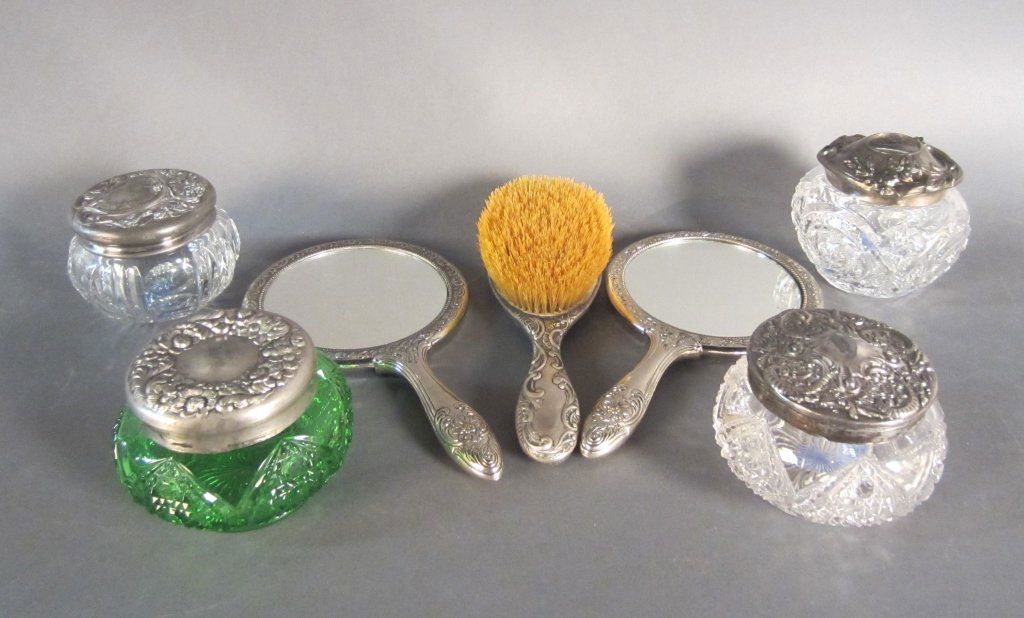 Collection of Vanity Accessories: From the estate of John McDonald Collection of Victorian Sterling and silver plate vanity accessories including 2 hand mirrors, hair brush and 4 glass jars with intricate metal tops.