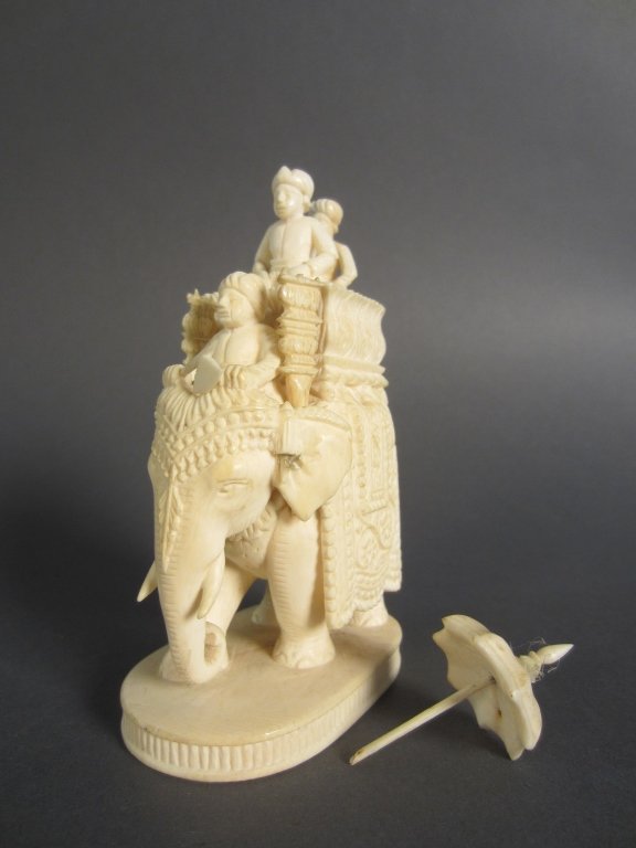 Carved Ivory Elephant: Carved ivory elephant with 3 riders. two of the riders are removable. Umbrella is detached and has old repairs. AS IS. Height: 4 3/4", Width: 3"