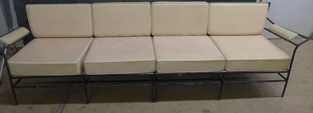 Mid Century Iron Outdoor Furniture Set: Collection of Mid Century painted black iron outdoor furniture with bamboo detail and peach colored cushions. Pieces include: 2 arm chairs, 1 ottoman, 1 loveseat, couch (2 sections), 2 tier side table