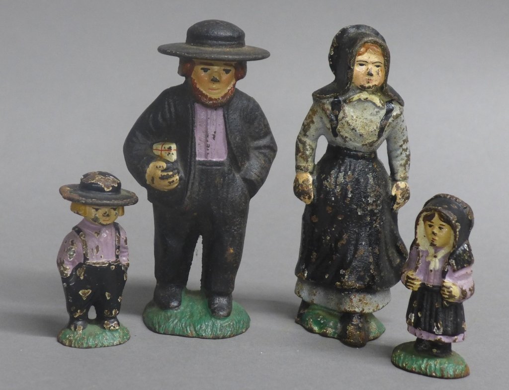 Cast Iron Amish Family Figurines: Collection of 4 hand painted cast iron Amish family figures. Some wear to the paint. Height of tallest: 4 1/2"