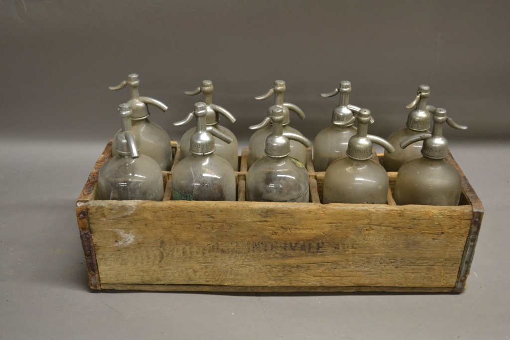 Vintage Seltzer Bottles: Collection of 10 vintage glass seltzer bottles in wood case. Brands on bottles include: John Scheu & Son and Clover Leaf Brand.