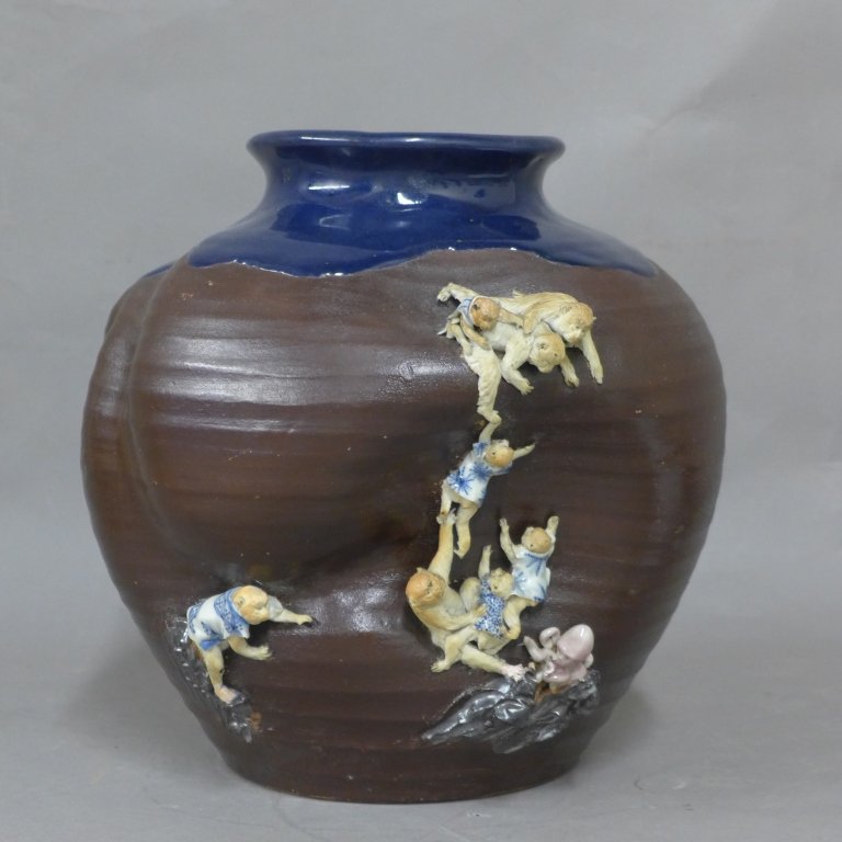 Japanese Sumida Art Pottery: Asian earthenware vase, art pottery. Sculpted monkeys climb up the vase, on dark brown glazed ground. Maker's mark on bottom. Some chips, missing fingers and age appropriate wear. Height: 11 3/4", Wid