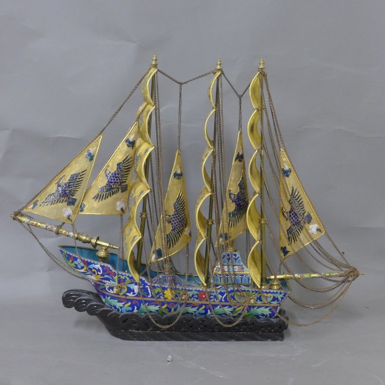 Chinese Cloisonne Sailing Ship/ Boat: Rare Chinese cloisonne enamel boat with golden filigree sails and carved wood "wave" base. In great condition. Height: 19", Width: 25", Depth: 7"