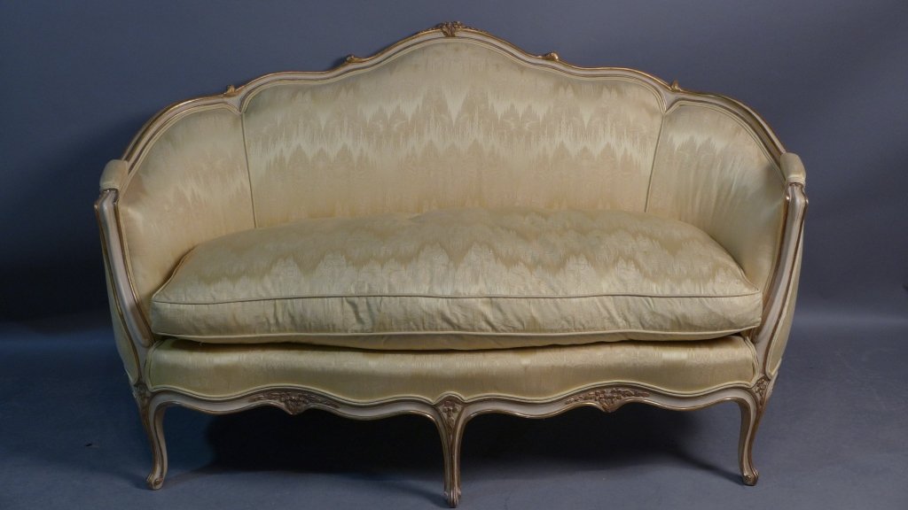 Louis XV Style Settee: Yellow upholstered and painted wood sette with gilt accents. Some wear to gilding and slight discoloration to armrest. Small cracks in frame on top. Fabric tag reads: W & J Sloane Inc, Established 184
