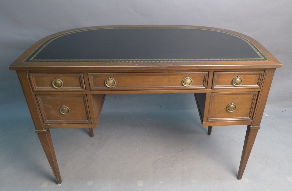 Leather Top Neoclassical Demilune Desk: Wood framed black leather top with antique gold tooling. Center drawer has pencil tray. Maker's mark in inside of center drawer: Sligh Furniture, Holland Michigan. Height: 29 1/8", Width: 42 5/8", Dep