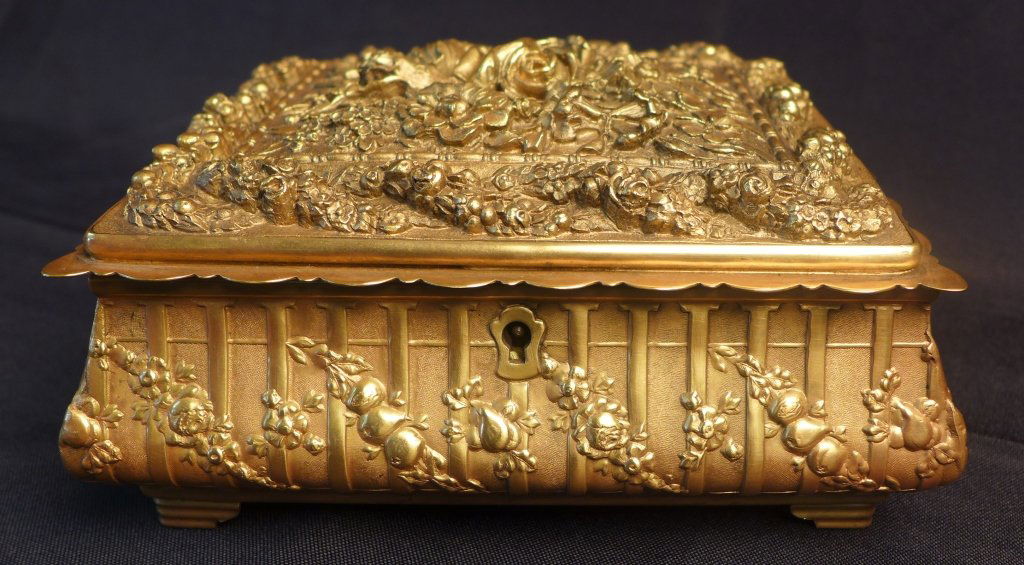Italian Antiqued Dore Silk Lined Box: Antiqued gold dore over bronze, rose decorated hinged box. Yellow silk lines the upper and lower portion inside the box. Mark on bottom. Made in Italy. Wear to lining. No key.Height: 3 1/2", Width: 7"