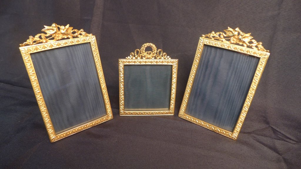 Assortment of 3 Gilt Picture Frames: Assortment of 3 dore over bronze picture frames. Varying sizes. Smaller frame is decorated with ribbon, wreath and a bow on top. Pair of larger frames are decorated with kissing birds on a flowering b
