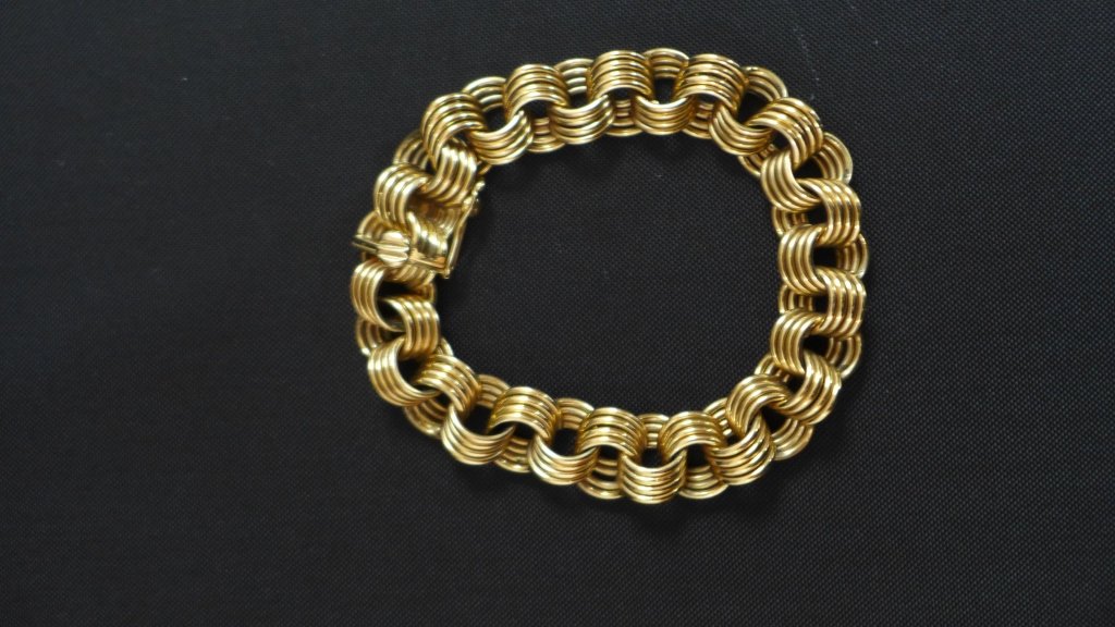 14k Yellow Gold Bracelet: 14KT yellow gold bracelet. The chain is made by looping gold around four times to create each link! Clasp is marked 14KT. This bracelet can stand on its own or with the addition of charms. Approx. 8"L