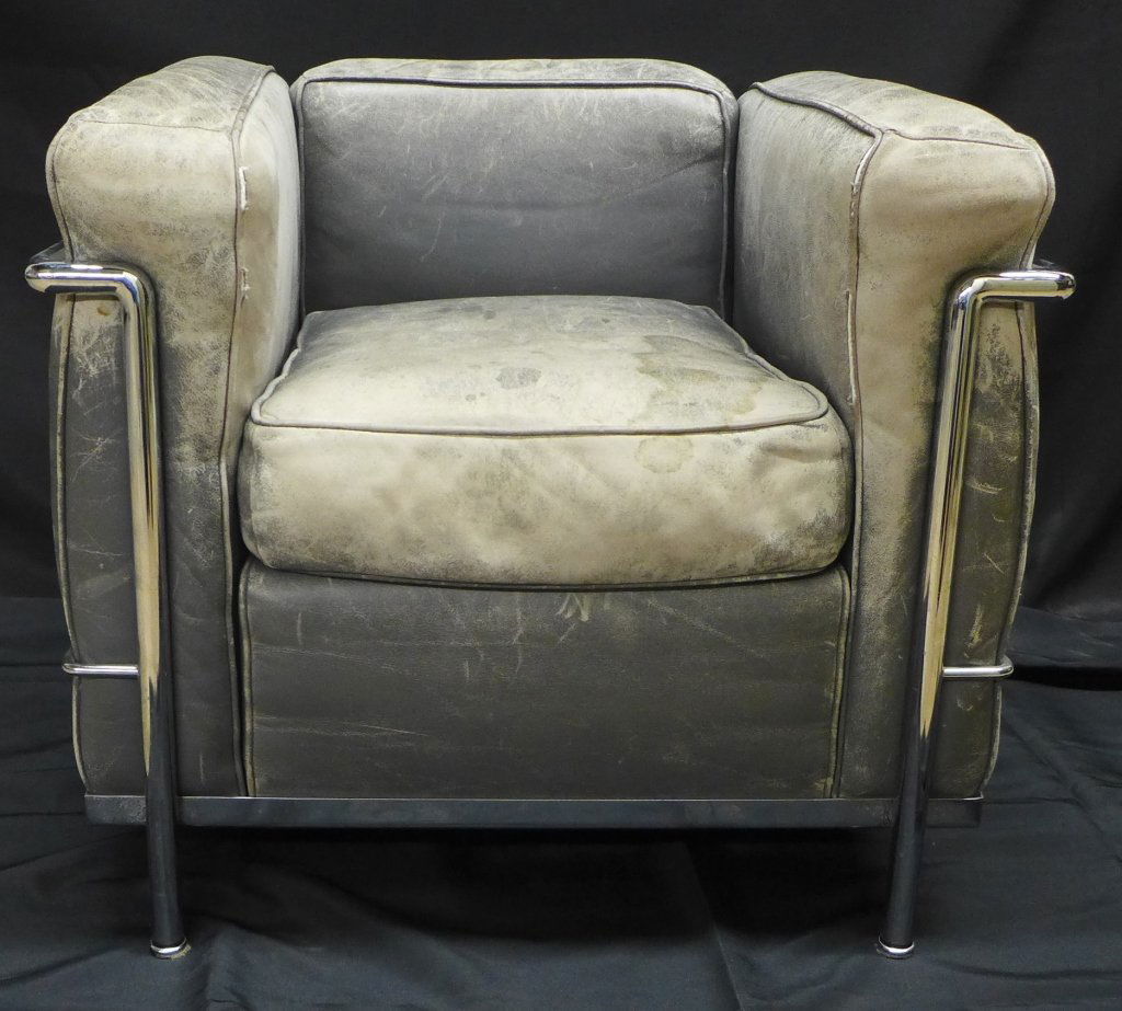 Le Corbusier LC2 Petit Modele Chair: Le Corbusier LC2 Petit Modele Chair is known for its cube-like form, this chair is also famous for the way its frame graces the exterior of the piece. This iconic grey leather chair has wear and disco