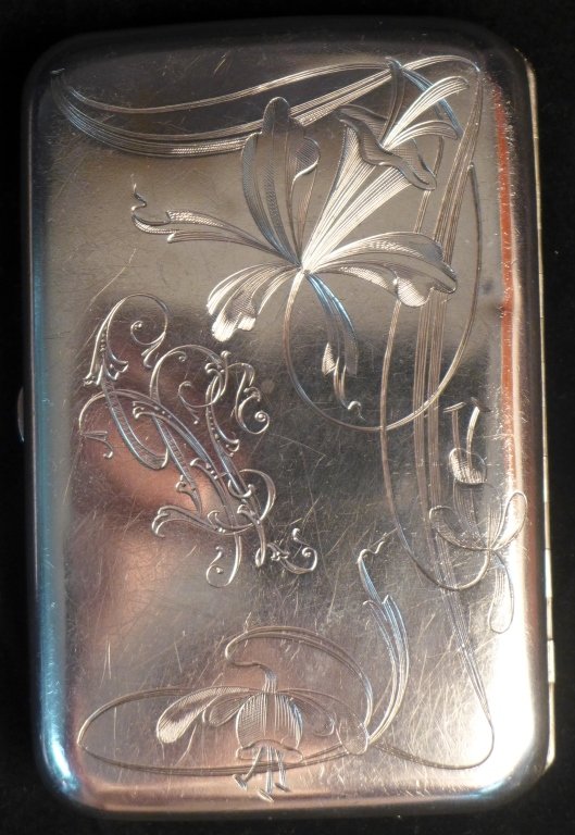Russian Silver Floral Etched Cigarette Case: Lady's sterling silver carrying cigarette case. Attractive floral design on front depicting lilies and monogram. Some surface scratches and wear to piece. Hallmarks. Marked 800 on both inner sides. Im