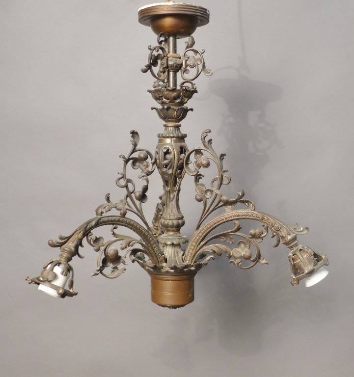 Antique Cast Iron 3 Arm Chandelier: Vintage Cast Iron chandelier constructed with 3 curved arms. Each arm curves down with foliate, flower, and leaf ornament design attached to urn shaped pierced body. Comes with 3 etched glass shades. 