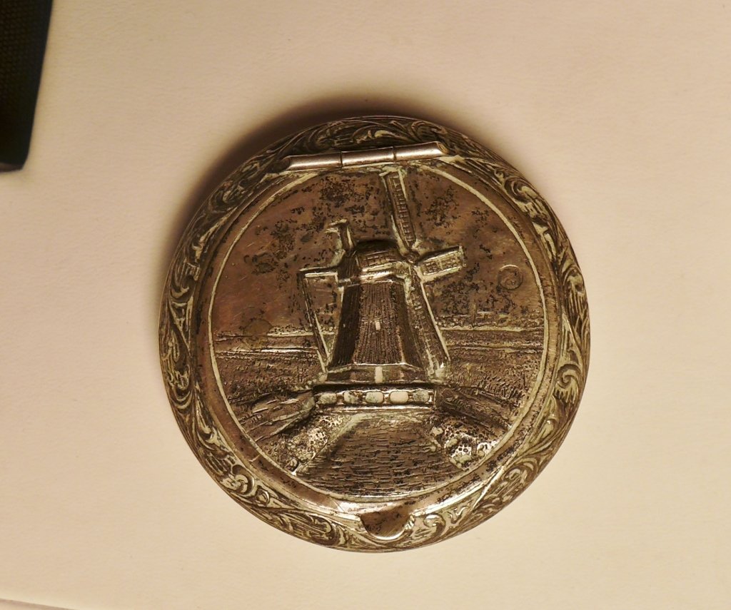 Vintage Sterling Silver Pill Case: Antique Dutch sterling silver pill box. Made with very detailed repousse work, with the top showing windmill and sides decorated with foliate scrolls. Stamped with Moerkerk & Co mark on the inside. Ag