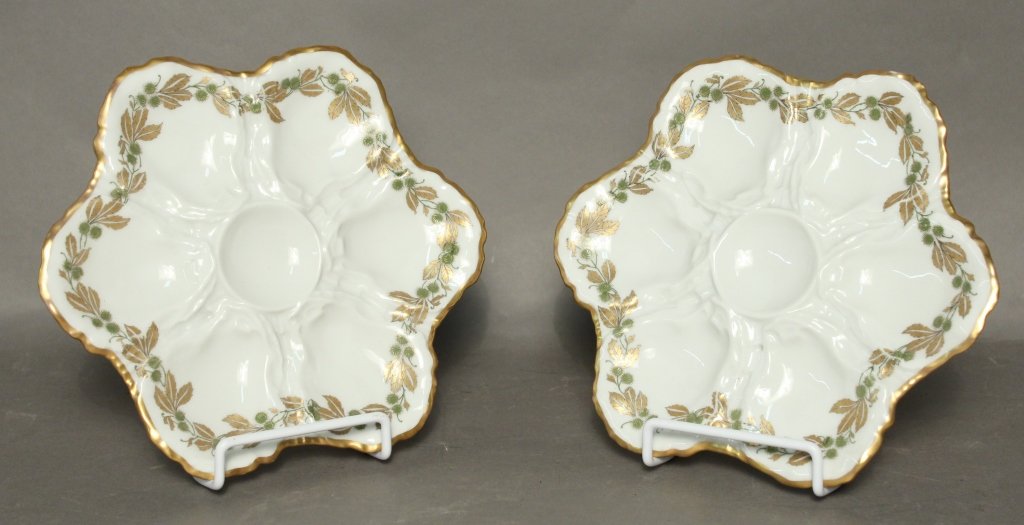 Limoges Oyster Plates: Two porcelain oyster plates with gilt and green decorative garland design around edge. Each holds 6 shells and center bowl for dipping. Maker's mark on back reads: Haviland France, Haviland & Co Limog