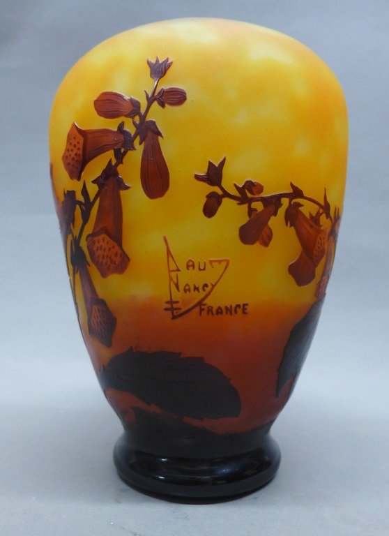 Daum Nancy Cameo Glass Vase: Beautiful and ornate cameo glass rimless vase with floral motif. Burgundy flowers on a yellow to orange ombre background. Signed: Daum Nancy France. Height: 9", Diameter: 6 1/4" (snap dragon, trumpet