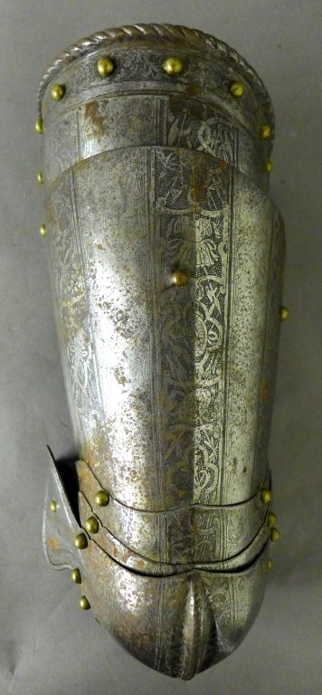 16th Century Italian Knee & Thigh Guard: Antique iron knee and thigh defense amour with ornate etched patterns and brass rivets. Appears to be missing one rivet. Some noticeable wear. Height: 16", Width: 6 1/2", Depth: 4" (military, militia,
