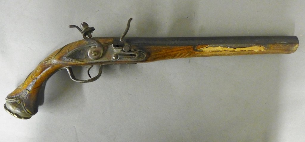 Antique Flintlock Pistol: Continental Flint Lock Pistol. Possibly Italian. Brass butt, trigger and decorative inlay. Iron barrel and lock. Noticeable damage to wood stock. Length: 18", Width:1 3/4" (gun, weapon, war, militaria