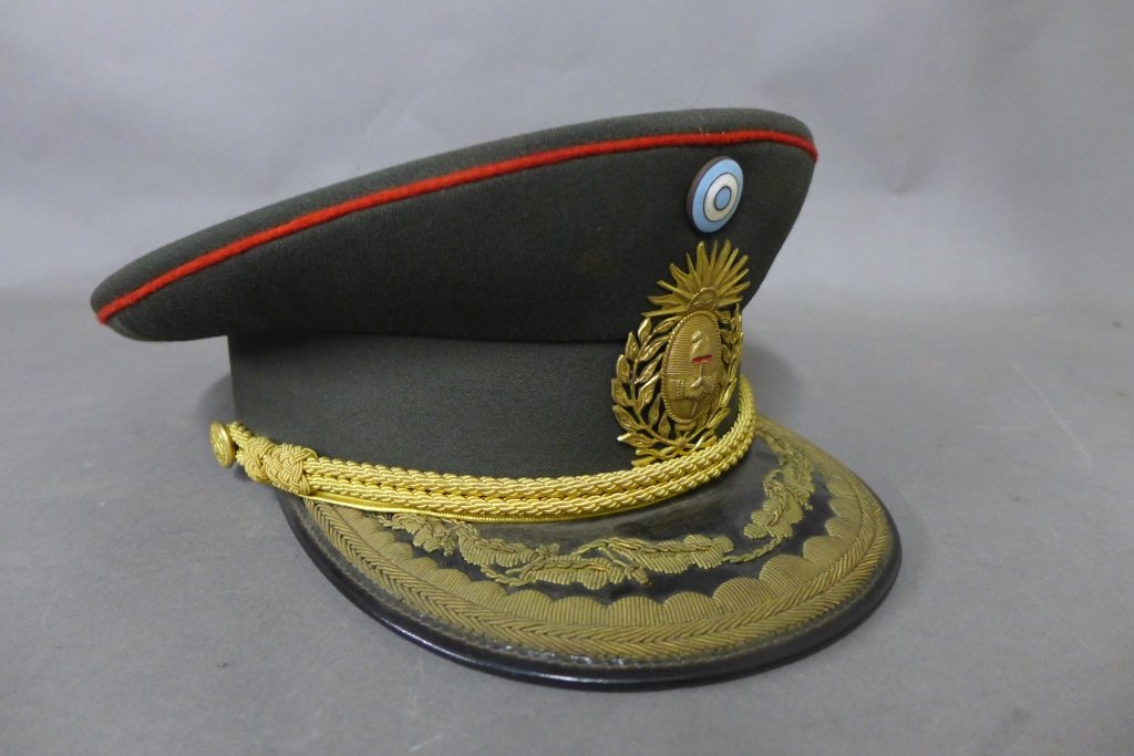 Argentine Army Military Hat: Hunter green officer's hat with cap badge, side buttons, rope accent and embroidery design on brim. Cap badge depicts: The Sun of May symbolizing the rising of Argentina, unity of provenances, and wil