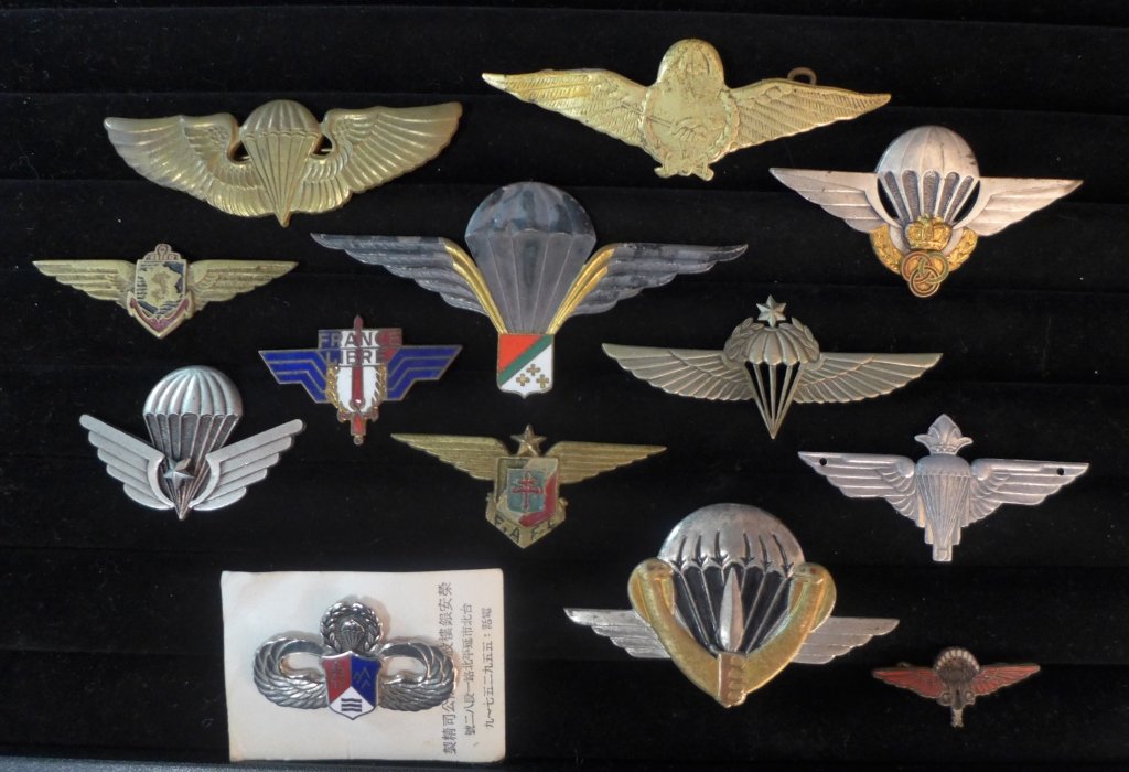 Paratrooper Jump Wing Badges: Assortment of 13 Paratrooper Jump Wing Badges. Includes Morocco, F.A. F.L., France Libre and many more.Maker marks.From the collection of Gene Christian.Height: 1 7/8" ; Width: 3 3/4". Age appropriate