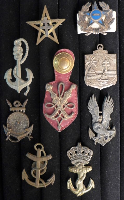 Badge Insignia Collection: 9 metal pin badge insignia of the Foreign Legion.Includes: Service ALGERIAN Affairs on leather fob, TDM RIMaP Nouvelle Caledonie, 7th Regiment Inter Weapons and more.Maker marks.From the collection of
