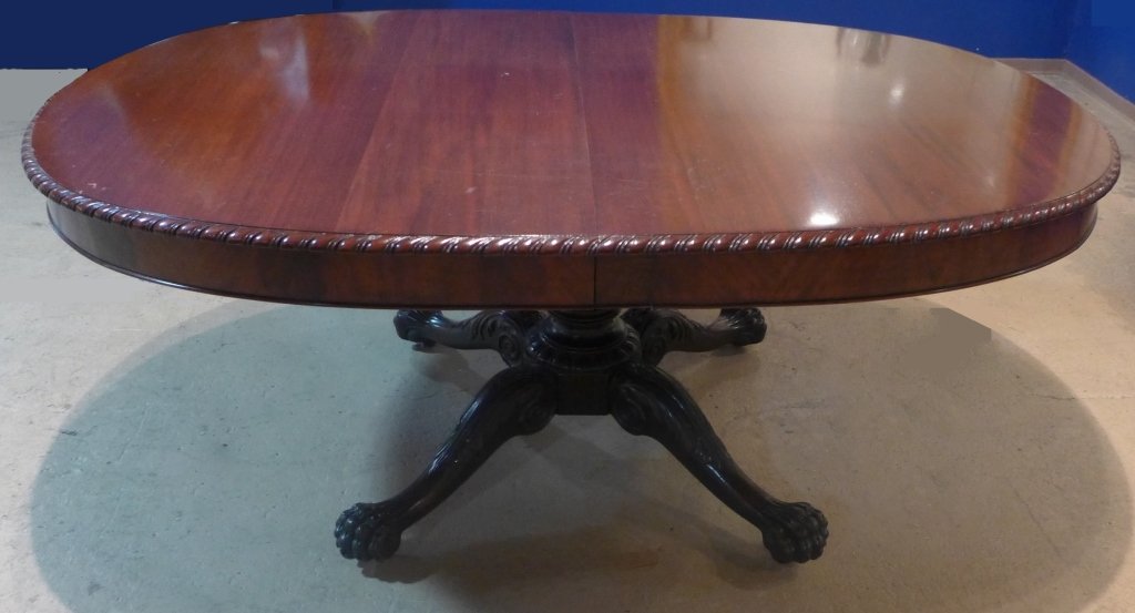 Antique Pedestal Dining Table: Beautiful Victorian mahogany oval dining table with pedestal base branching out into four paw feet. No additional leaves. 19th Century. Some noticeable imperfections and scratches. Height: 30", Width: