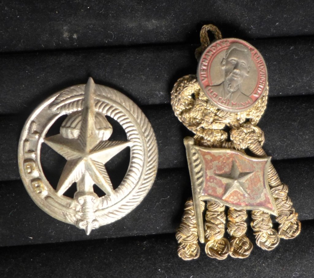 Viet Nam Badge Insignias: Two Viet Nam Badge Insignias. Vietnam War Metal Cap Badge - ARVN (Special Forces) and Viet Nam dan chu cong hoa ho chi minh badge insignia with flag pin on braided rope crown symbol. From the collecti