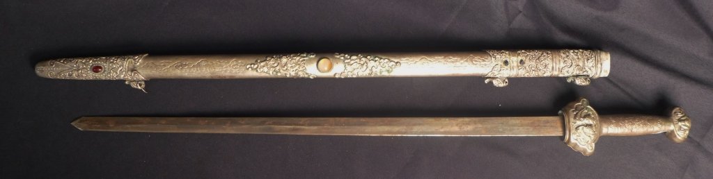 Jian Double Edged Strait Sword with Sheath: Jian Double Edged Strait Sword with Sheath. Handle and sheath are richly decorated with engravings, Repoussé and chasing and inlaid stones. Maker marks. From the collection of Gene Christian. Height: