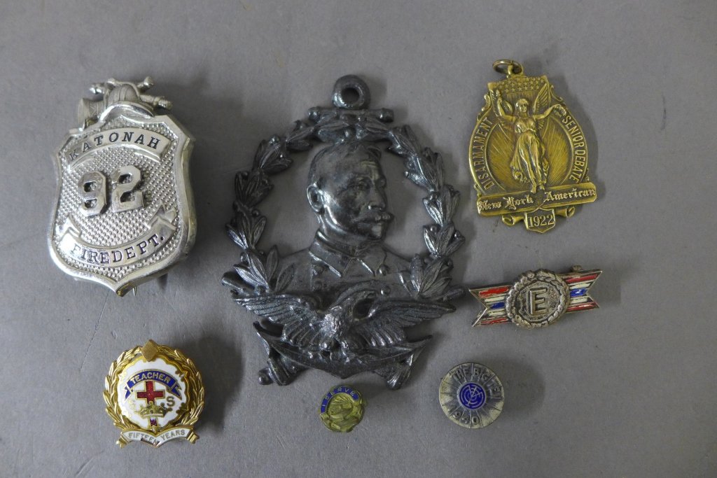 Vintage American Badges and Medals: Collection of seven vintage US military badges, pins and medals. -Metal medallion depicting USA Bald Eagle with anchor, cannons, portrait and wreath. -"I serve" circle military pin with blue enamel ba