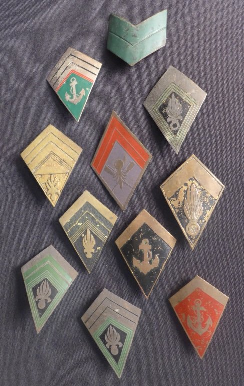 Collection of Brass Military Rank Chevron Badges: Assortment of 11 pieces featuring grenade flames, anchors and more.From the collection of Gene Christian.Height: 2 3/4" ; Width: 1 3/4". Age appropriate wear. STERLING ASSOCIATES STRIVES TO PROVIDE AC
