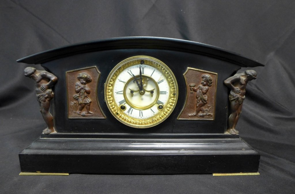 Ansonia Mantle Clock: Black marble shelf clock with figural bronze mounts. Bottom of clock face reads: Manufactured by the Ansonia Clock Co. New York United States of America. Face of clock also has "A" maker's label. Cloc