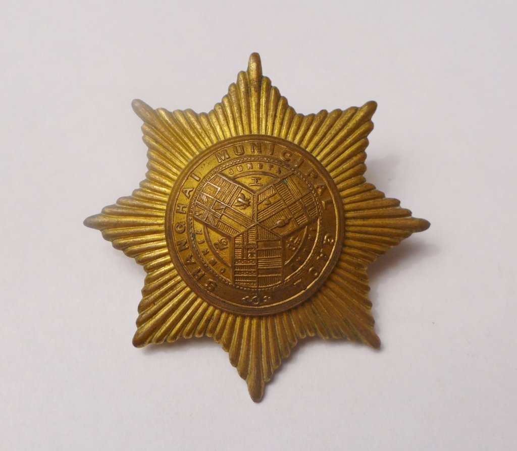 Shanghai Municipal Gaol Cap Badge: Shanghai Municipal Gaol cap badge. Featuring brass tone eight pointed star incorporating and flags of all nations in the centre. _x000D_ Imperfections. Diameter: 2"_x000D_ From Gene Christian Collecti