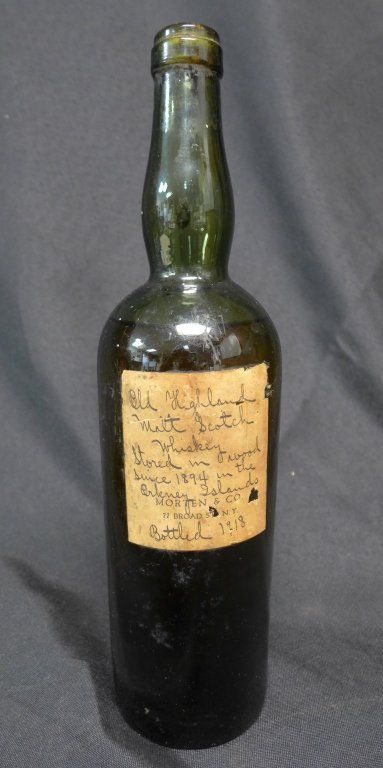 Old Highland Single Malt Scotch: Old Highland Single Malt Scotch Whiskey. Label reads: Stored in wood since 1894 in the Orkney Islands, bottled 1918, Morten & Co, 77 Broad St, NY. This whiskey was stored in wood casks between 1894 an