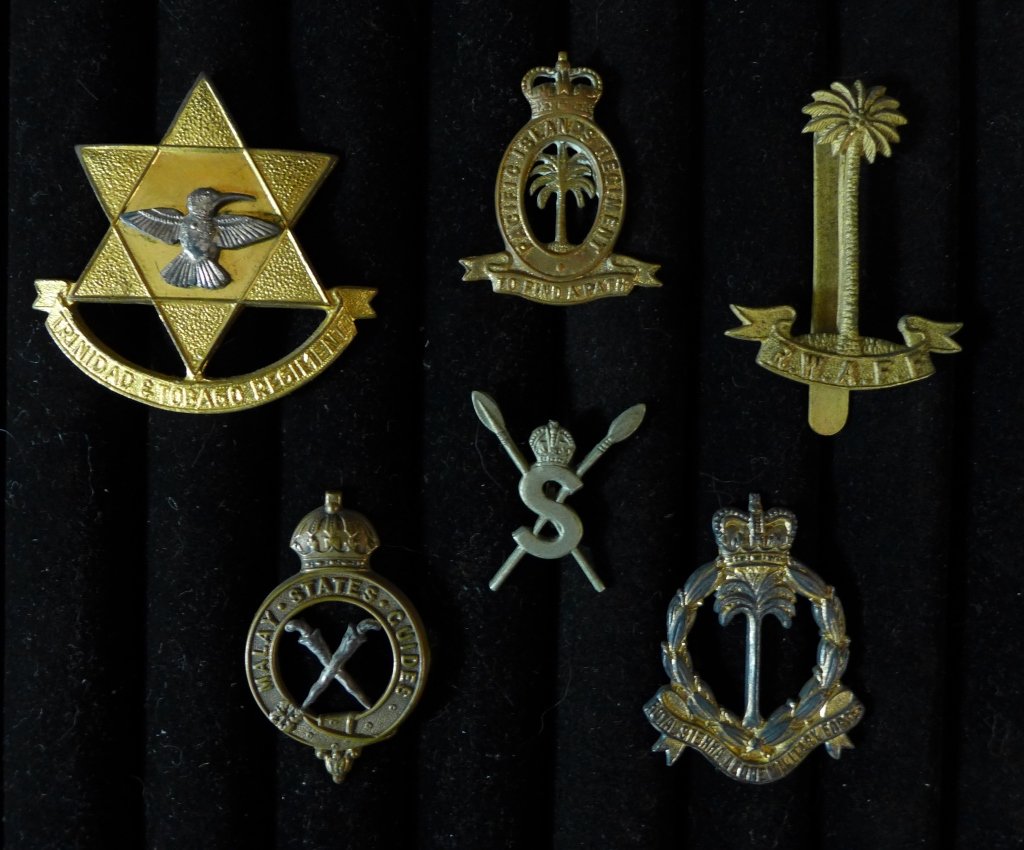 Collection of British Colonial Badges: Assortment of 6 badges includes: -Trinidad & Tobago Regiment. Height: 2" ; Width: 2". -Malay States Guides. A Victorian era Officer's pattern cap badge. -Royal West Africa Frontier Force (R.W.A.F.F.) 