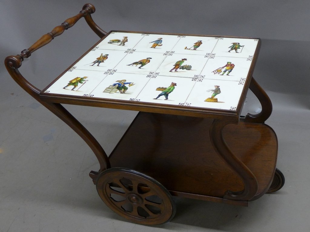 Tea Cart Server with Artisan Tile Top: Unique vintage wood tea cart. 12 vintage square ceramic tiles, each depicting a man at a different activity. Has bottom shelf and three wood wheels. Circa 1940s. No noticeable maker's marks. One on th