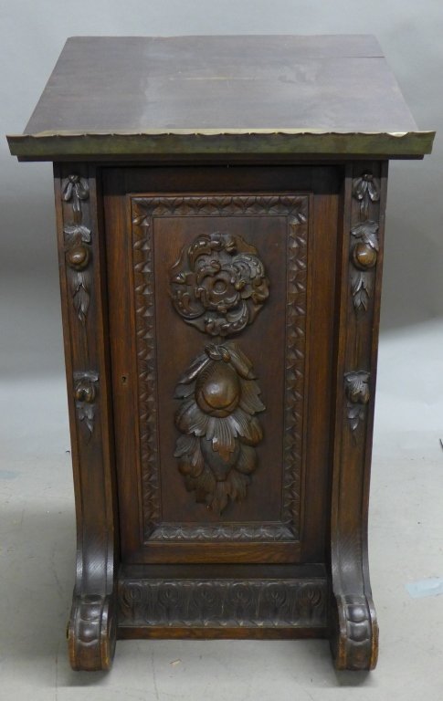Antique Carved Wood Lectern: Beautiful carved wood stand with a sloping top to hold Bible. Gothic Revival style. Hinged door opens for storage, no key. Brass bent panel/ book rest with scalloped edge on slanted top. Bottom back w