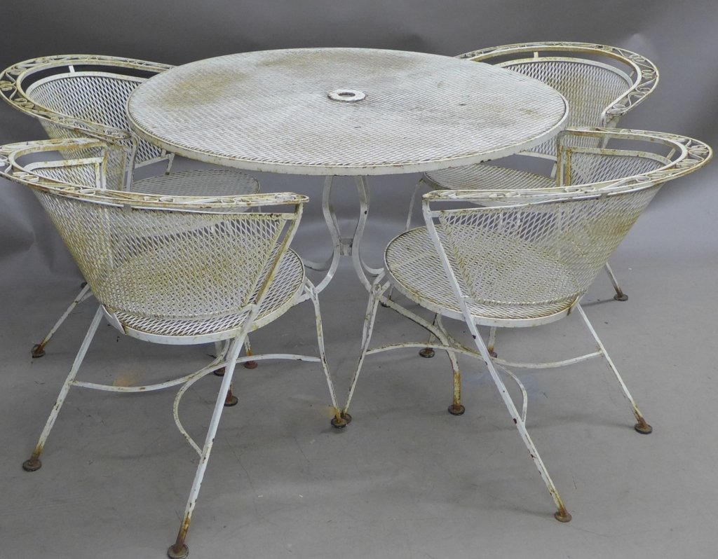Outdoor Furniture Set: Vintage metal outdoor table and chairs, painted white. Patio furniture. Chairs have steel mesh back and seat with scrolling accent design on legs and top. Table has mesh top and pedestal base. Some no
