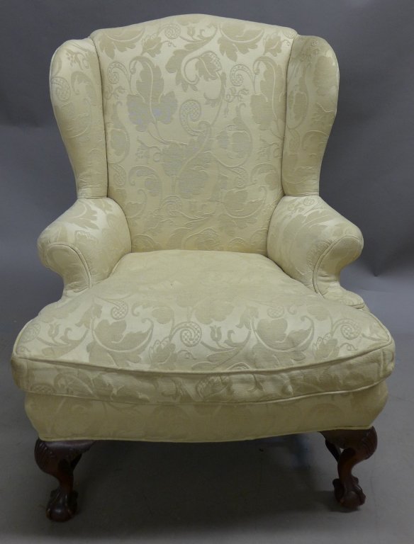 19th Century Chippendale Wingback Chair: Large upholstered Chippendale wingback Chair. Beautifully carved wood base with carved shell detail and legs terminating with ball and talon feet. Some discoloration to upholstery. Height: 44", Width: