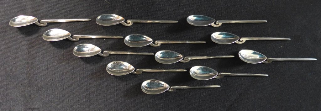 Sterling Silver Tea Spoons: Collection of 12 sterling silver tea spoons. Sleek modern design with scrolling accent. Maker's mark on side, tested positive for sterling silver with a nitric acid test. Some slight surface scratches