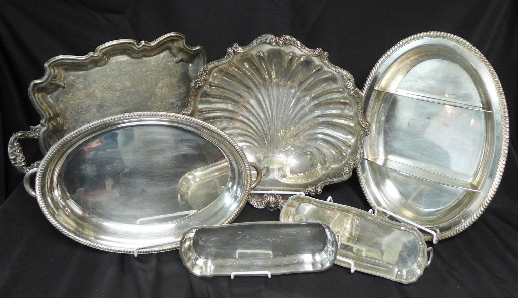 Group of Silver Plate: Collection of 6 silver plate pieces. Serving trays and platters. Highlighted in this assortment is a large serving dish in the shape of a shell with a lovely scrolling boarder with foliage accents. Sh