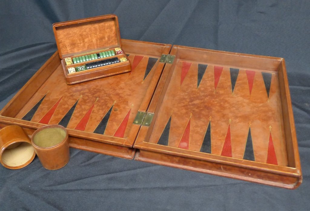 Folding Book Form Chess/ Backgammon Board Game: Vintage folding chess board in the form of a pair of books with gilt-tooled leather bindings, opening to reveal a backgammon board with original dice shakers and gaming pieces. Height: 3 3/8", Width: 