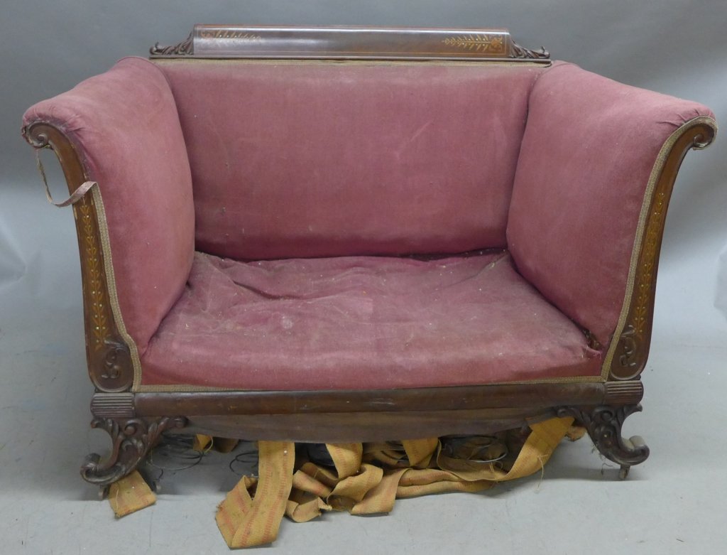 Victorian Loveseat: Victorian upholstered loveseat. Carved wood frame has lovely marquetry design which includes mother of pearl accents. Four legs terminate on small castor wheels. Some wear and noticeable damages. Heig