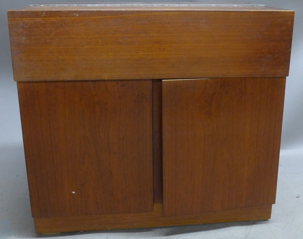 Mid Century Flip Top Bar Cabinet: Modern bar cabinet/ storage unit with hinged fold-away design. Bottom cabinet doors open to reveal additional shelving. No noticeable maker's marks. Some noticeable wear on top. Height: 28 1/2", Width